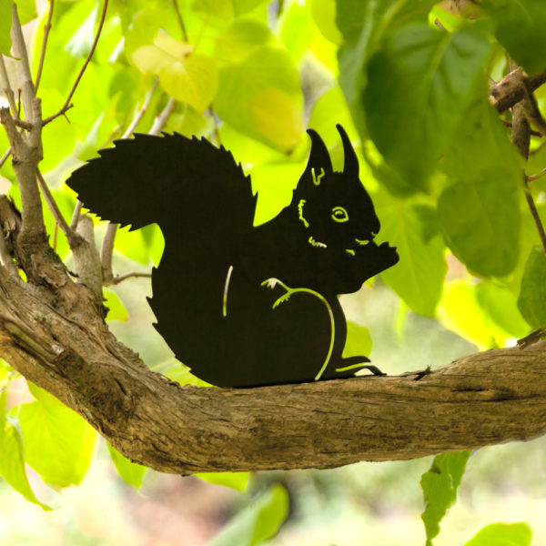 zdjęcie metalowej wiewiórki na drzewie